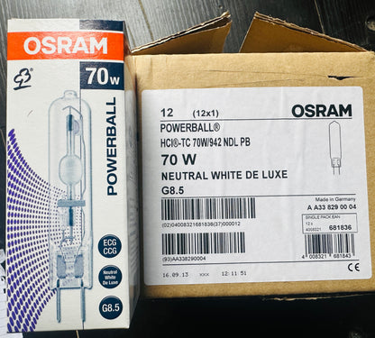 Two OSRAM POWERBALL 70W neutral white light bulbs in their original retail packaging, shown side-by-side on a dark wooden surface.
